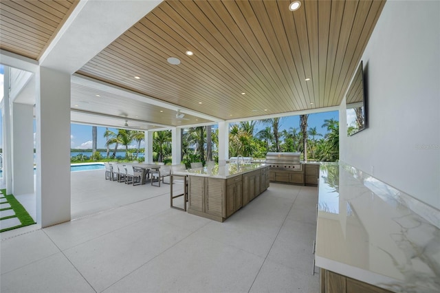 view of patio featuring an outdoor pool, a grill, an outdoor kitchen, and outdoor dining space