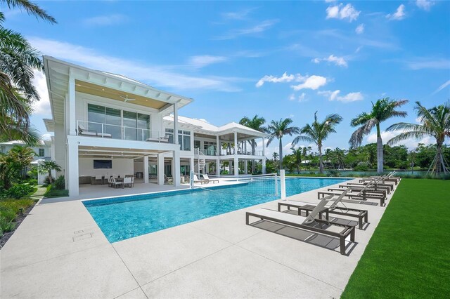 pool with a patio area, a ceiling fan, and a lawn