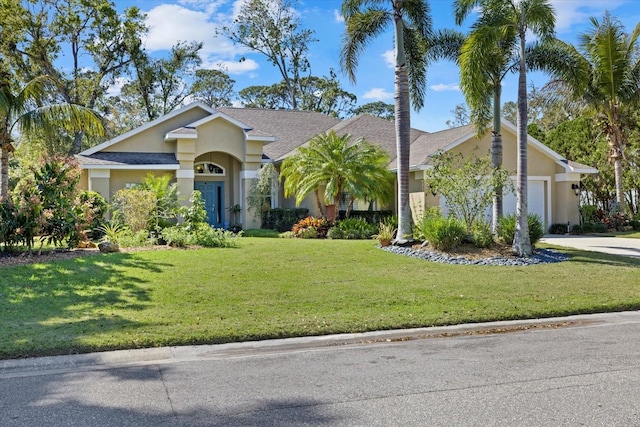 view of front of house with a garage, driveway, a front lawn, and stucco siding