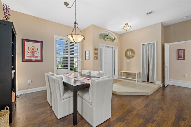 dining area featuring dark wood-style flooring, visible vents, and baseboards