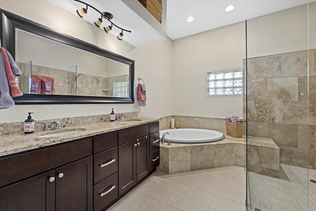 full bath with a garden tub, a sink, tiled shower, and tile patterned floors