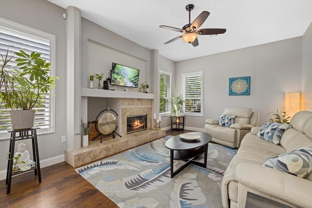 living room with baseboards, a premium fireplace, wood finished floors, and a healthy amount of sunlight