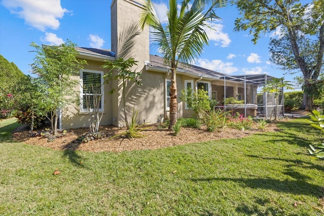 view of property exterior featuring glass enclosure, a yard, and stucco siding