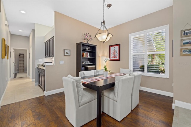 dining room featuring baseboards, hardwood / wood-style floors, and recessed lighting