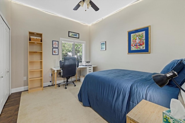 bedroom with a closet, ceiling fan, baseboards, and wood finished floors