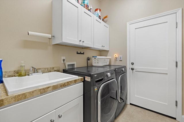 laundry area with light tile patterned flooring, independent washer and dryer, a sink, and cabinet space