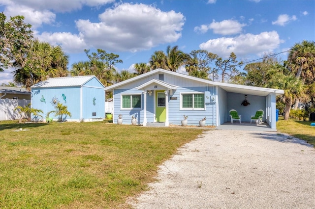 view of front of home with a front yard, driveway, and an attached carport