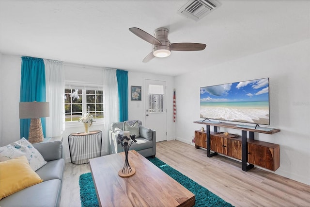 living room featuring visible vents, ceiling fan, baseboards, and wood finished floors