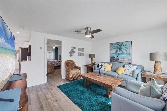 living room featuring light wood finished floors, visible vents, a ceiling fan, and recessed lighting