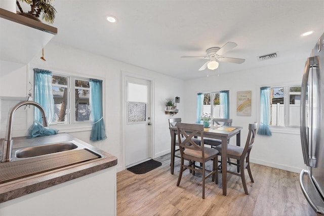 dining room with baseboards, visible vents, and light wood finished floors