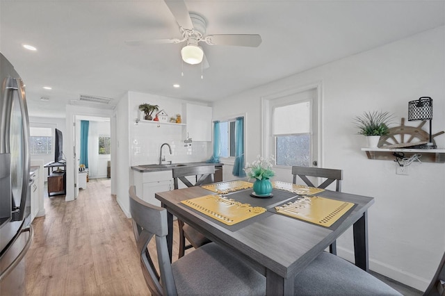 dining space with light wood-type flooring, baseboards, a ceiling fan, and recessed lighting