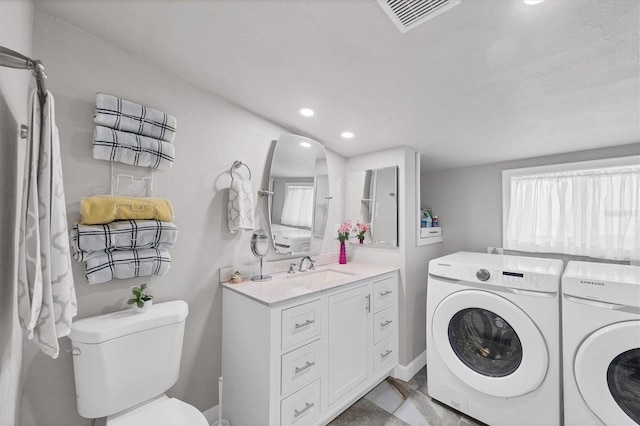 laundry area with laundry area, visible vents, independent washer and dryer, a sink, and recessed lighting