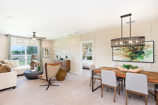 interior space with a decorative wall, a ceiling fan, visible vents, and light colored carpet