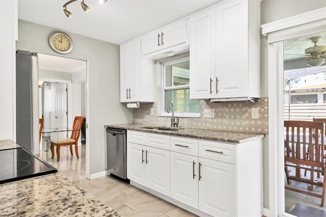 kitchen with stainless steel appliances, white cabinetry, a sink, and backsplash