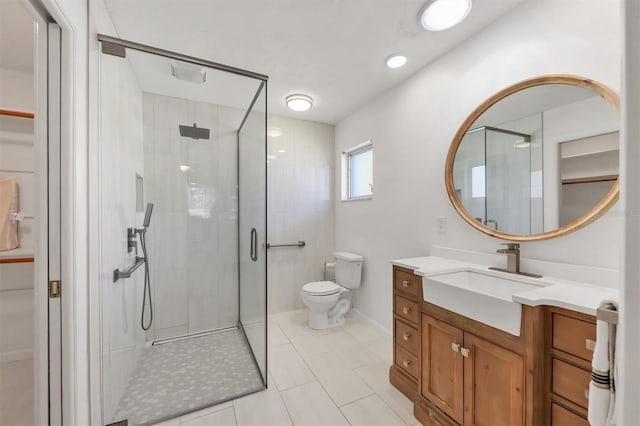 bathroom with a stall shower, vanity, and toilet