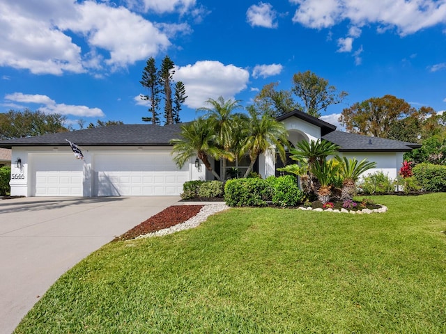 view of front of home featuring a front yard, concrete driveway, an attached garage, and stucco siding