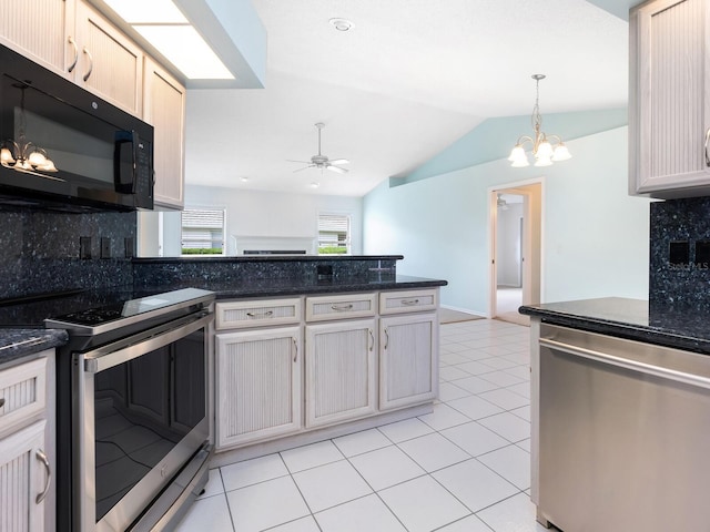 kitchen featuring light tile patterned floors, a peninsula, vaulted ceiling, stainless steel appliances, and ceiling fan with notable chandelier