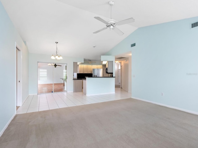 unfurnished living room featuring light carpet, visible vents, light tile patterned flooring, vaulted ceiling, and ceiling fan with notable chandelier