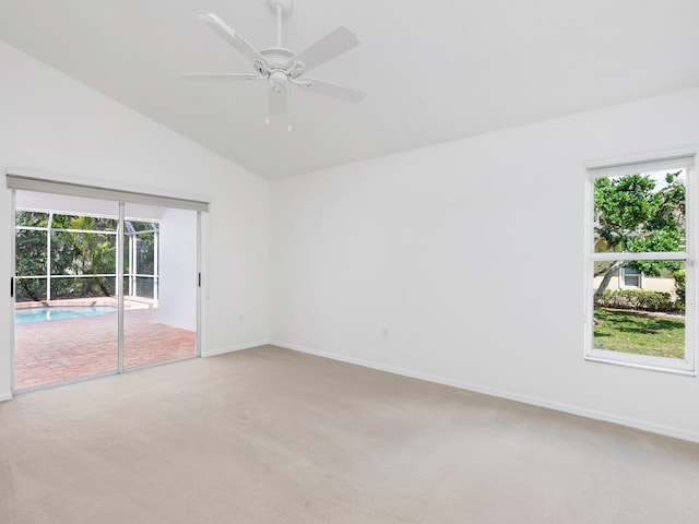 spare room with baseboards, vaulted ceiling, a ceiling fan, and light colored carpet