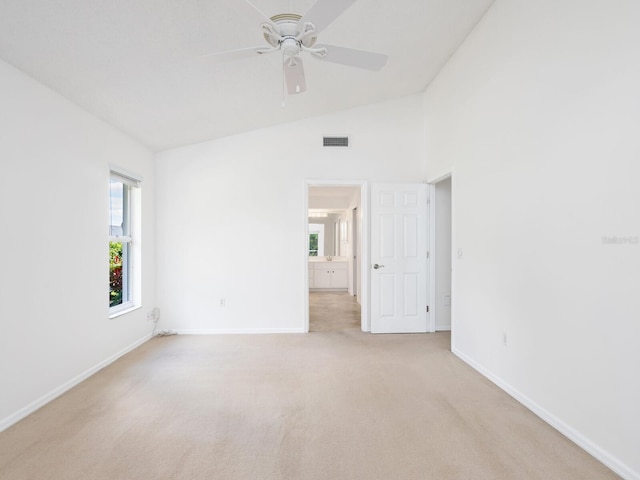 interior space featuring light carpet, vaulted ceiling, plenty of natural light, and visible vents