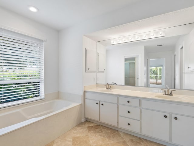 bathroom with a stall shower, double vanity, a sink, and a bath