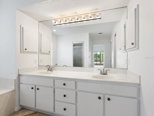 full bathroom with double vanity, a washtub, an enclosed shower, and a sink