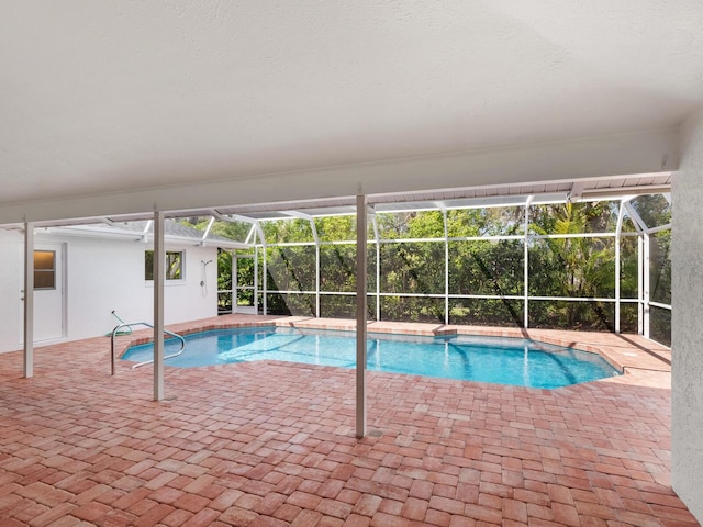 outdoor pool featuring glass enclosure and a patio area