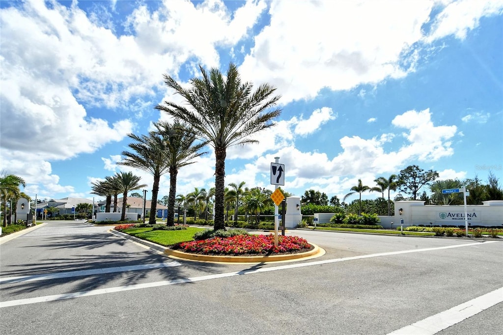 view of road featuring curbs, a gated entry, and traffic signs