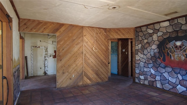 empty room featuring wood walls and visible vents