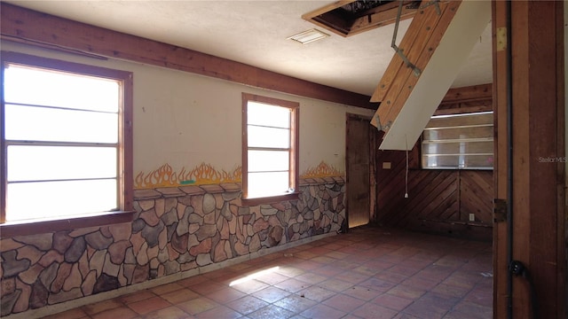 spare room with a wainscoted wall and visible vents