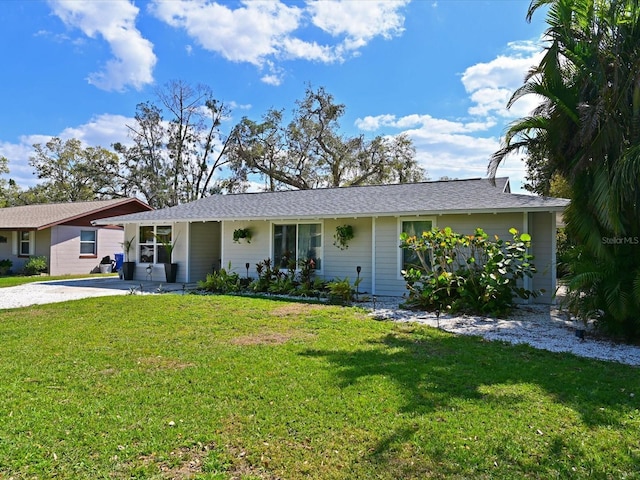 ranch-style house featuring driveway and a front lawn