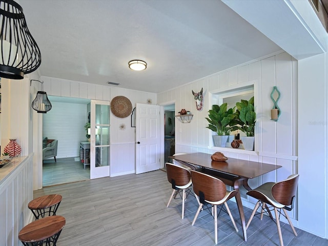 dining area featuring light wood-style flooring and visible vents