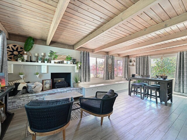 interior space featuring a fireplace with raised hearth, wooden ceiling, wood finished floors, and beam ceiling