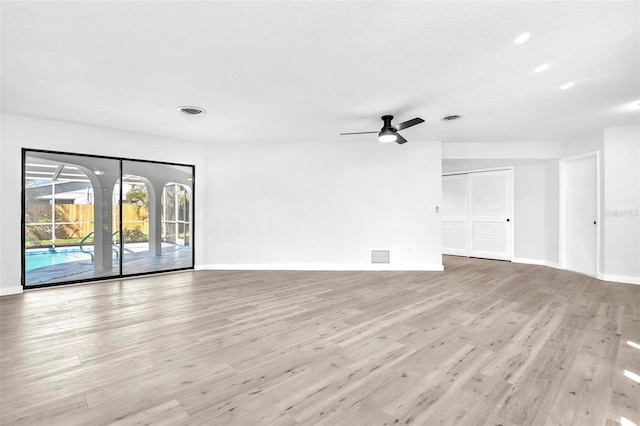 spare room featuring baseboards, visible vents, and wood finished floors