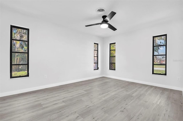 unfurnished room featuring a ceiling fan, baseboards, visible vents, and wood finished floors