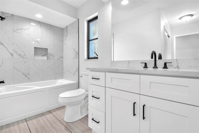 full bathroom featuring toilet, recessed lighting, wood finished floors, vanity, and washtub / shower combination