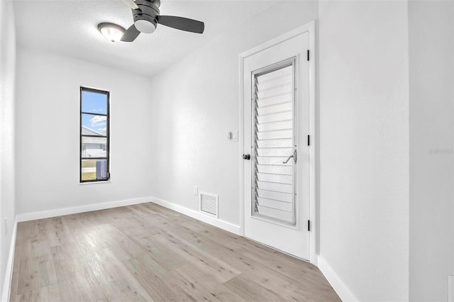 empty room featuring baseboards, wood finished floors, visible vents, and a ceiling fan