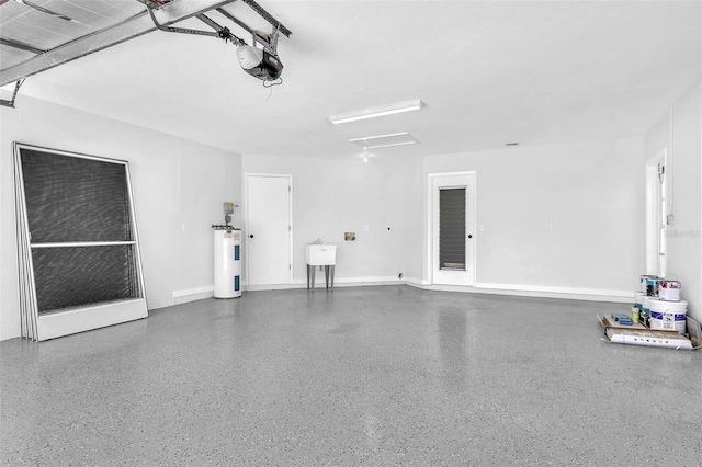 garage featuring baseboards, a garage door opener, and electric water heater