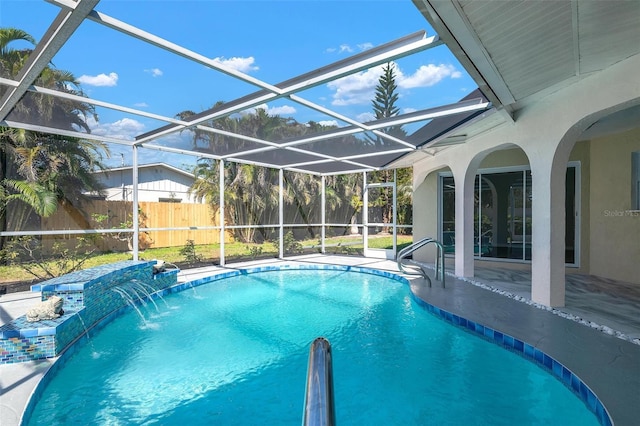 view of pool with glass enclosure, a fenced backyard, a fenced in pool, and a patio