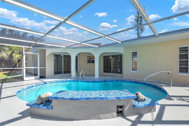 outdoor pool featuring glass enclosure and a patio area