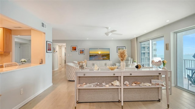 living area featuring light wood finished floors, baseboards, visible vents, a ceiling fan, and recessed lighting