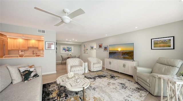 living room with recessed lighting, visible vents, ceiling fan, light wood-type flooring, and baseboards