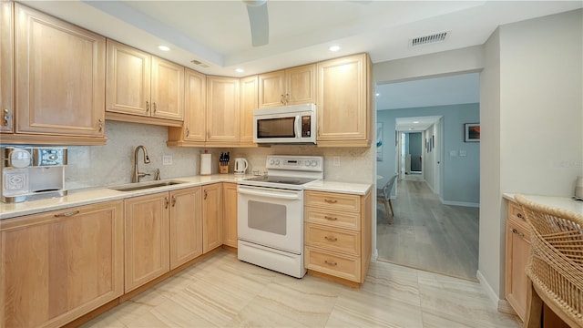 kitchen with white range with electric cooktop, visible vents, decorative backsplash, light brown cabinets, and a sink