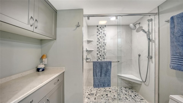 bathroom with toilet, a stall shower, and vanity