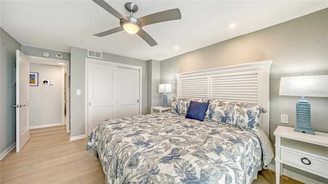 bedroom featuring a closet, visible vents, ceiling fan, light wood-type flooring, and baseboards