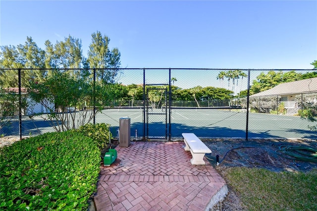 view of tennis court featuring a gate and fence