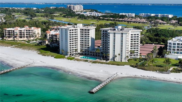 drone / aerial view featuring a view of city, a water view, and a beach view