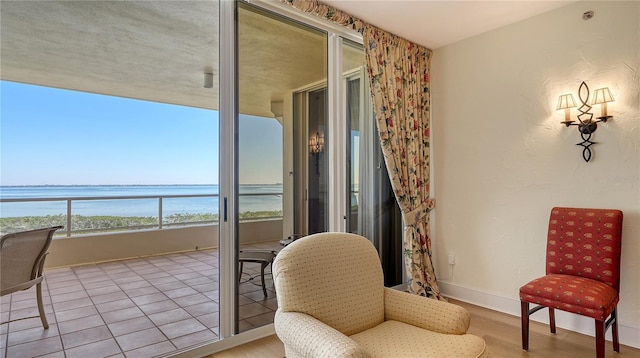 sitting room featuring baseboards and a water view