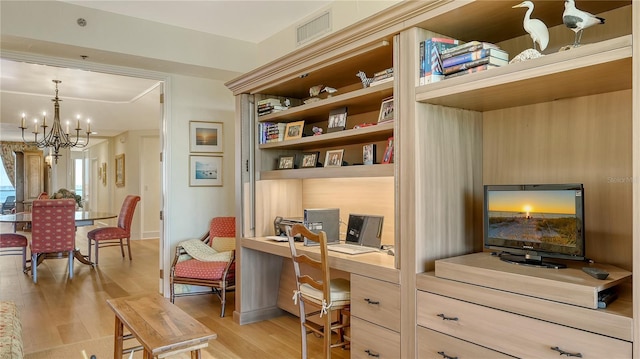 sitting room with visible vents, a chandelier, light wood-style flooring, and built in study area