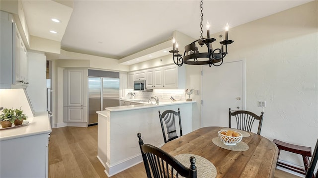 dining room featuring recessed lighting, a notable chandelier, and light wood-style flooring